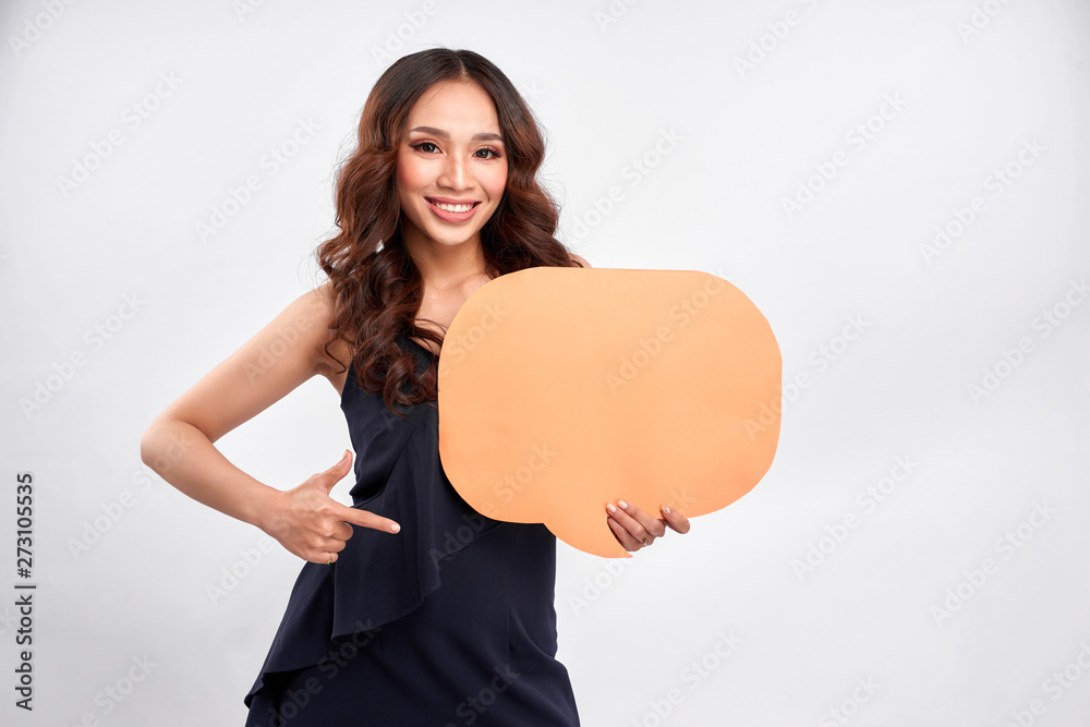 Young asian woman holding blank speech bubble on gray background. Horizontal shape, front view, waist up, copy space Young asian woman holding blank speech bubble on gray background. Horizontal shape, front view, waist up, copy space