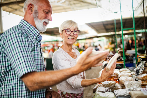 Portrait of beautiful elderly couple in market buing food