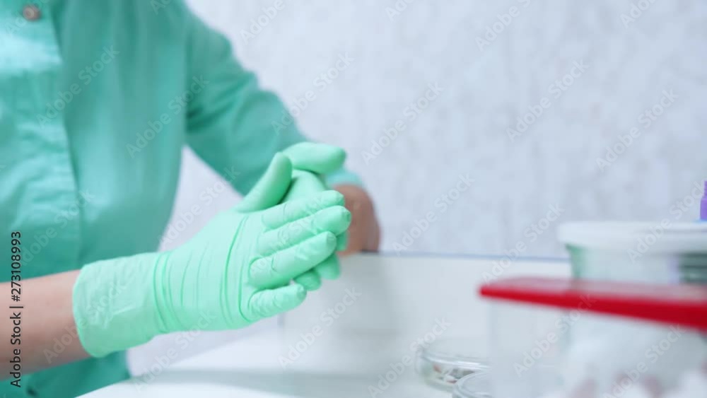 Dental Doctor cleaning and disinfecting her hands before dental treatment. Teenager treats teeth at the dentist. Dental Doctor cleaning and disinfecting her hands before dental treatment. Teenager treats teeth at the dentist.