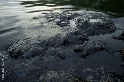 Oil sludge contaminating the sea during the oil spill disaster in Samet Island, Rayong, Thailand.