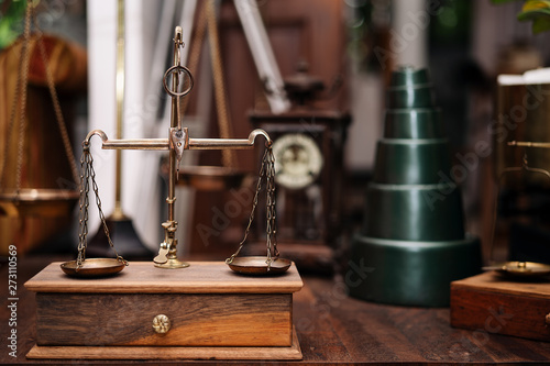 Many kind of old fashioned balance scales on wooden table. Colorful ancient balance scales in vintage background, isolated. the symbol of Lawyer. Royalty high quality free stock image.