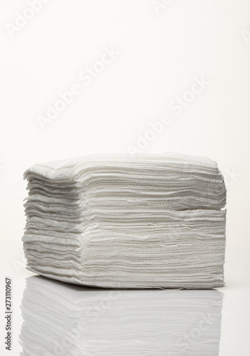 A stack of new white paper napkins on a white background