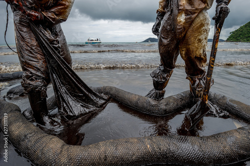 volunteers cleaning up a beach from a oil slick on Ao Phrao beach on Samed Island, rayong, Thailand. 