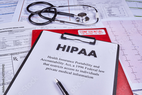 Health Insurance Portability and accountability act HIPAA, red folder with inscription confidential, pen and stethoscope on the medical documents background