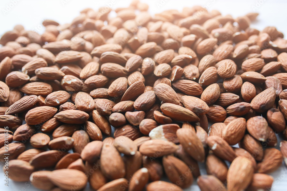Almond nuts lying on white background. Healthy food. Vegan concept. Lifestyle. Vertical. Almond nuts lying on white background. Healthy food. Vegan concept. Lifestyle. Vertical.