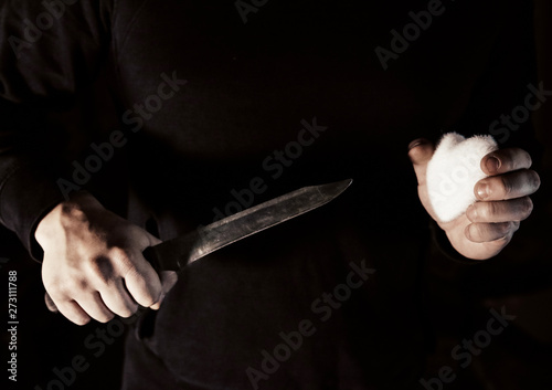 Man holding knife and toy heart in hands. Unhappy love concept. Broken feelings.