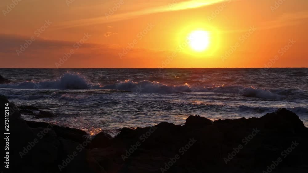 Sunrise on the rocky coast of the Spanish town Torrevieja. A slow motion shot. The wave jumps up in front of the sun and causes a big spray. Very romantic. Sunrise on the rocky coast of the Spanish town Torrevieja. A slow motion shot. The wave jumps up in front of the sun and causes a big spray. Very romantic.