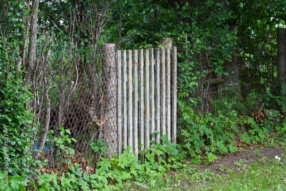 Countryside view of old wood fence doors near metal fence. Countryside view of old wood fence doors near metal fence.