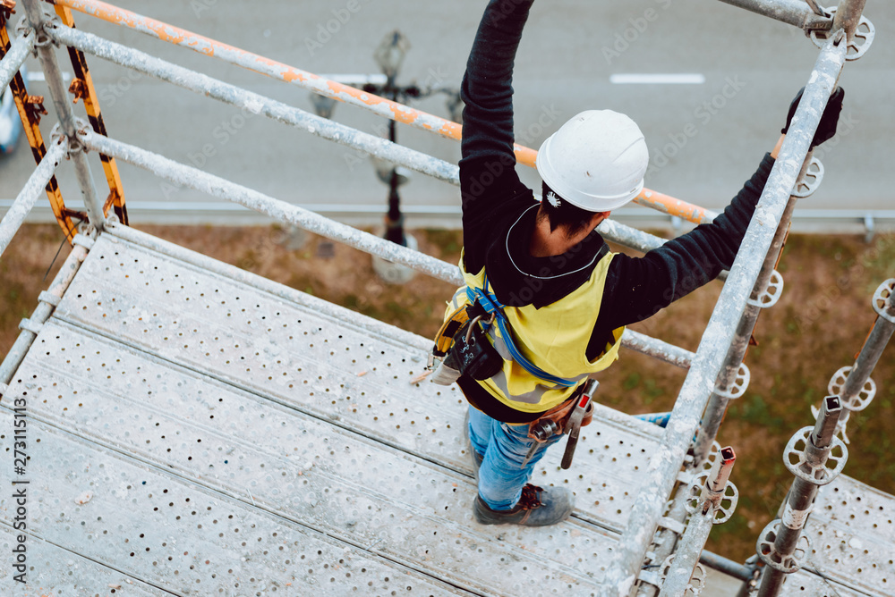 workers work removing a scaffolding at high altitude in Oviedo, Asturias, Spain. workers work removing a scaffolding at high altitude in Oviedo, Asturias, Spain.