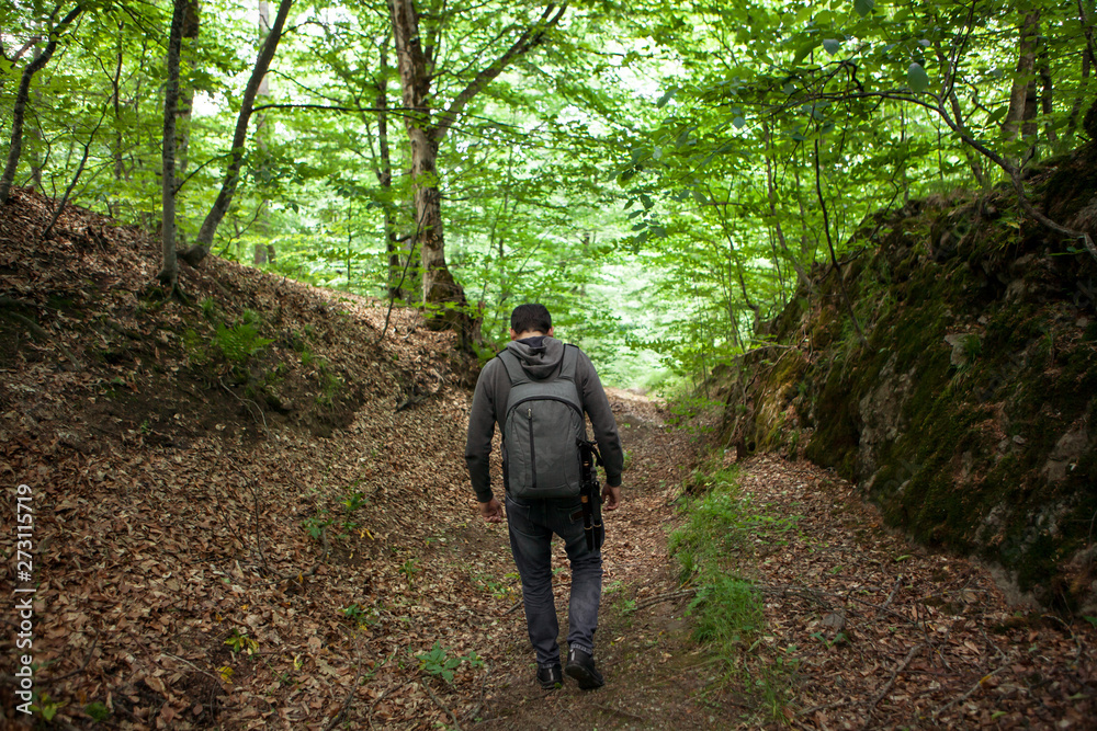 young man with a backpack in the forest young man with a backpack in the forest