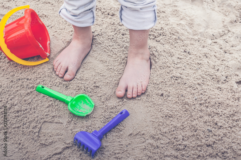 Children's feet in the sand and sandboxing equipment. Children's feet in the sand and sandboxing equipment.