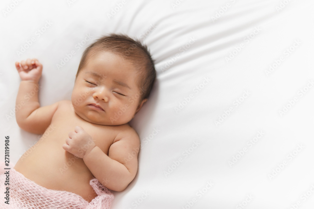 Adorable asian newborn baby in pink wrap sleeping on white blanket background. Adorable asian newborn baby in pink wrap sleeping on white blanket background.