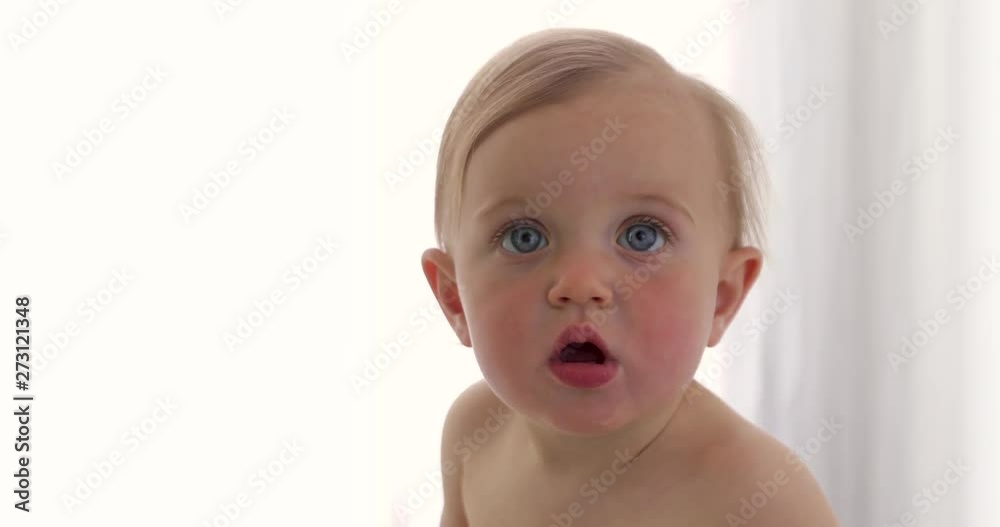 Close up baby of ten months. Portrait of a surprised baby with big blue eyes on white background Close up baby of ten months. Portrait of a surprised baby with big blue eyes on white background