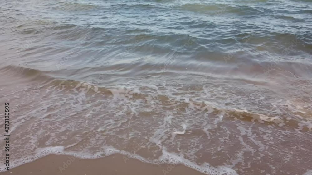 Waves in the ocean and sand on the beach, blue sky sunny day in Thailand Waves in the ocean and sand on the beach, blue sky sunny day in Thailand