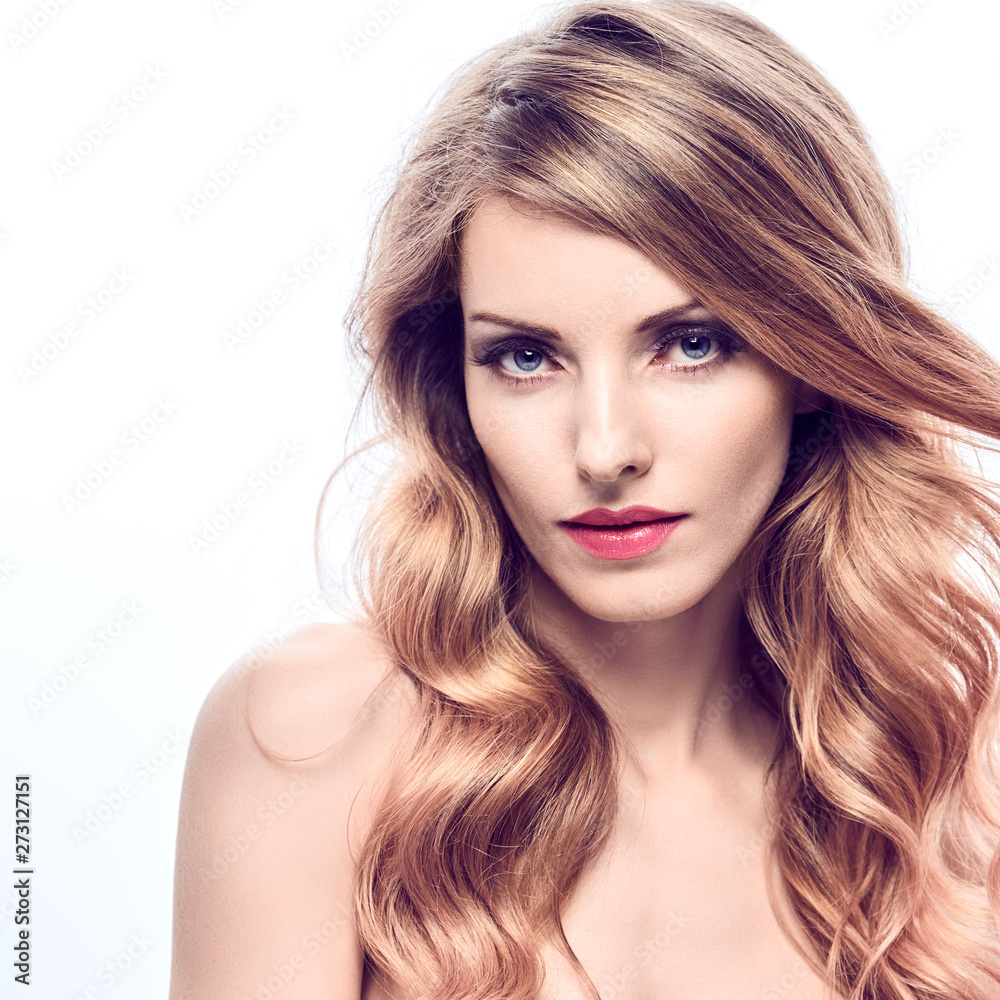 Fototapeta premium Portret kobiety moda uroda. Zmysłowa młoda blondynka z modną falującą fryzurą zdrową skórę, makijaż. Piękna uśmiechnięta dziewczyna pozytywny model, modna stylizacja kręcone włosy. Koncepcja makijażu produktów do pielęgnacji skóry