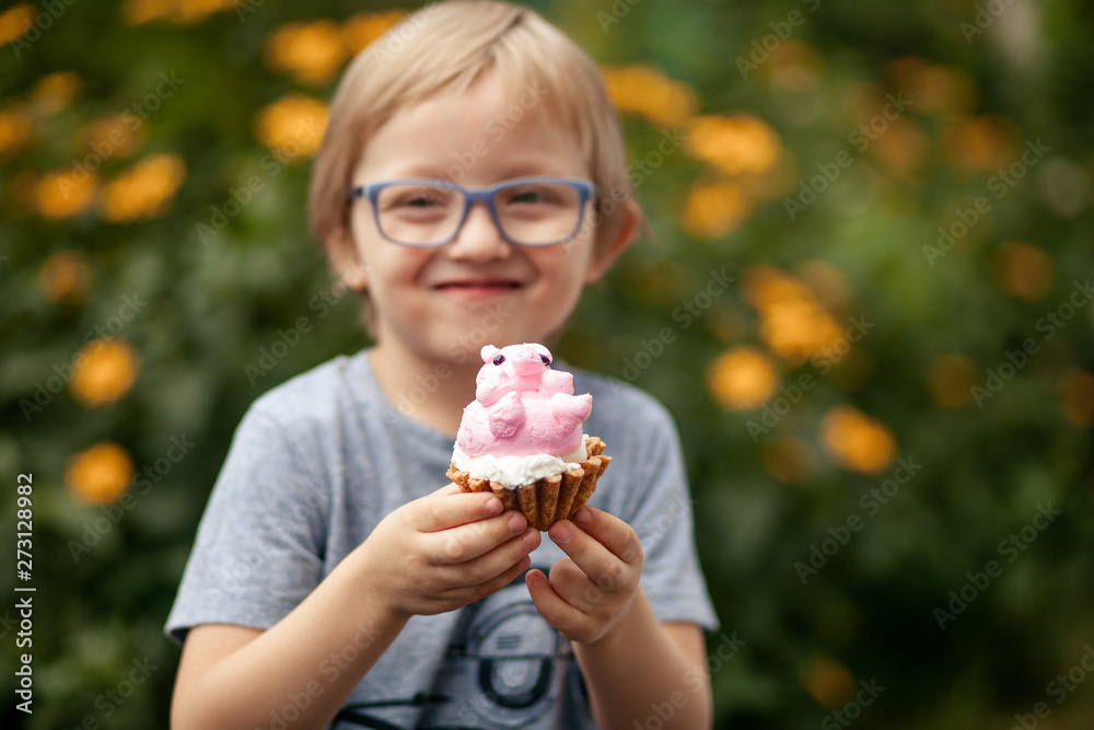 a happy child, a boy of 4-5 years old, is eating a delicious cake in the form of a pig