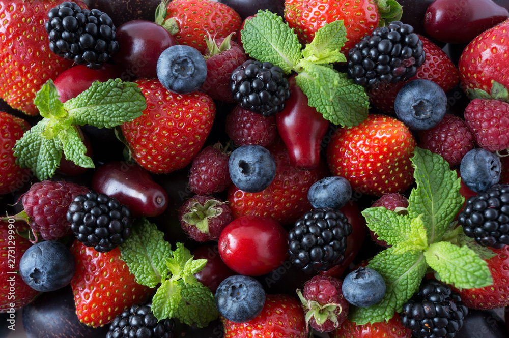 Obraz premium Ripe strawberries, blackberries, blueberries, raspberries, red berries abd plum. Mix berries and fruits. Top view. Background berries and fruits. Black-blue and red berries and fruits.