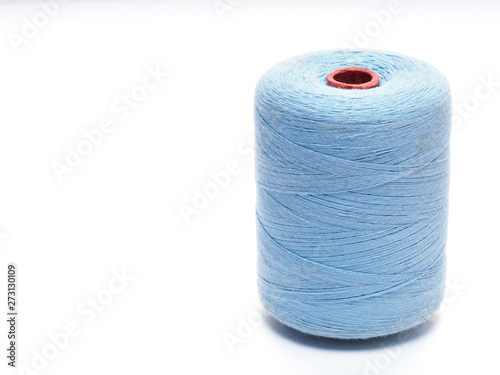Blue spool of thread in a vertical position on a white background