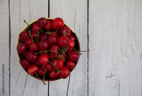 ripe red sweet cherry in a bowl on a wooden table