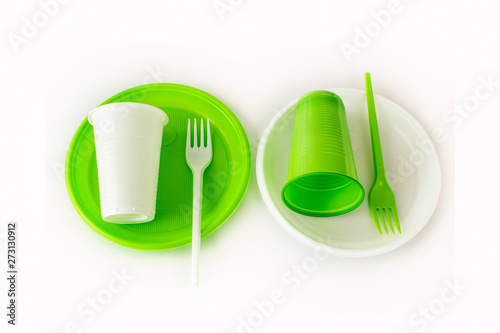 Light green and white set of disposable plastic tableware isolated on white background. Cups  plates and fork. Picnic set. Top view.