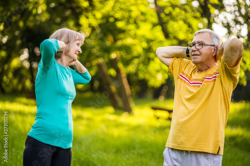 Senior couple is exercising in park.