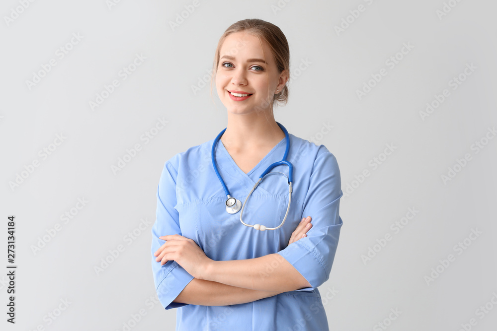 Young medical assistant on grey background Young medical assistant on grey background