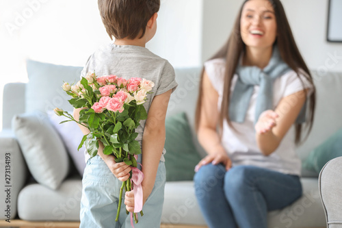 Little boy hiding bouquet o...