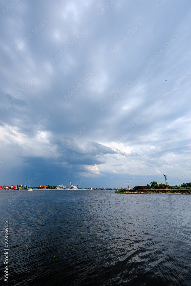 storm clouds forming over Riga cargo shipping port on river Daugava storm clouds forming over Riga cargo shipping port on river Daugava