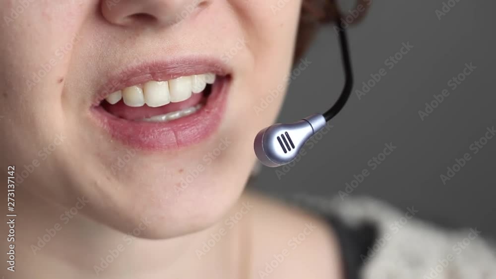 Closeup of a call center girl at work. She smiles while talking to the client