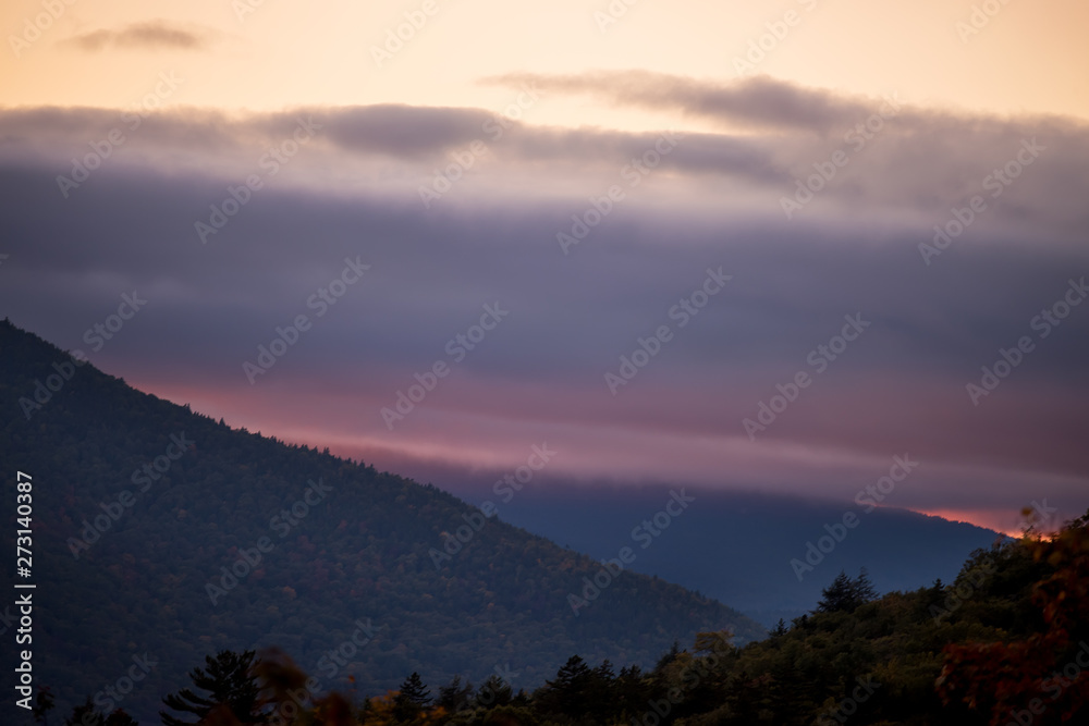 Fototapeta premium Mountains at sunset covered with dramatic clouds. Wild beautiful USA nature. White Mountain National Park. USA. New Hamshire.