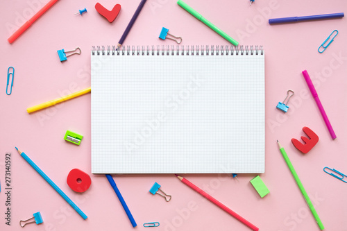 Various school accessories on pink board with copy space. Concept back to school.