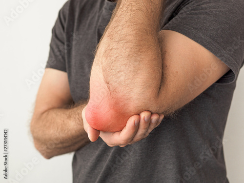 Photography man holds a painful elbow