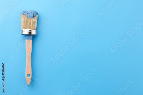 Fototapeta Naklejka Na Ścianę i Meble -  Brush tool in blue paint on blue background, copy space