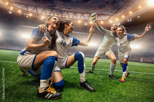 Happy Female Soccer players on a professional soccer stadium. Girls Team emotionally celebrates victory © Alex