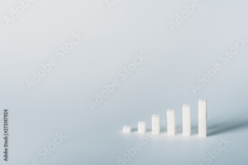 white sugar cubes arranged in stacks on grey background with copy space