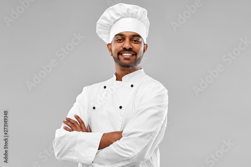 Fotografie cooking, profession and people concept - happy male indian chef in toque over gr