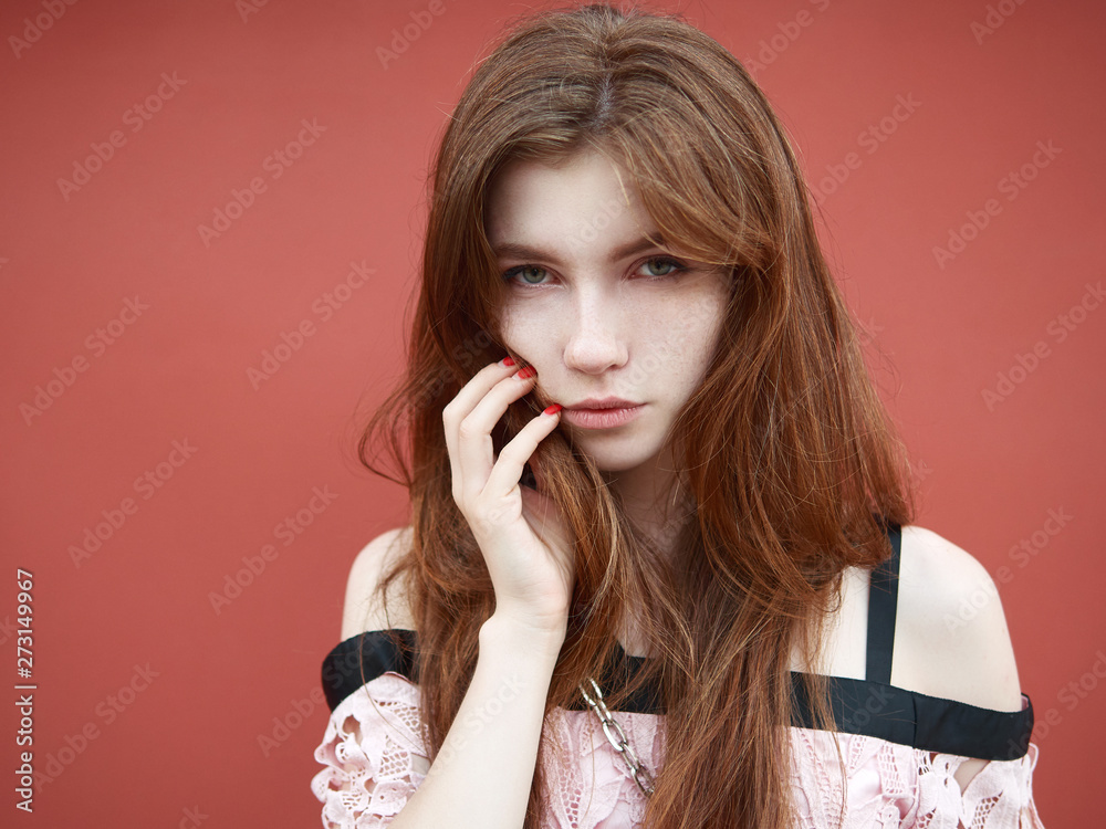 Headshot of young adorable redhead woman model with freckles and shiny pale skin dressed in trendy pink blouse with bare shoulders posing outdoors enjoying warm summer evening posing outdoors against Headshot of young adorable redhead woman model with freckles and shiny pale skin dressed in trendy pink blouse with bare shoulders posing outdoors enjoying warm summer evening posing outdoors against