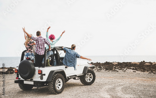 Fotografie Group of friends driving off road convertible car during roadtrip - Happy travel