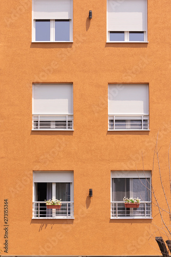 Fragment of a low-rise new building with fresh plaster and windo