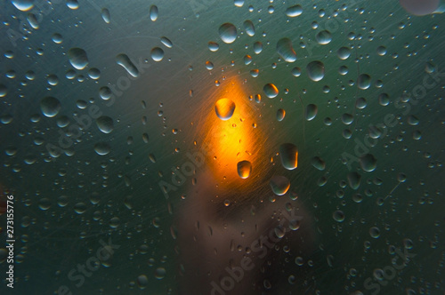 Abstract blurred background with a candle and raindrops close-up