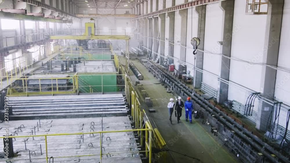 High-angle shot of factory senior executives giving tour for foreign colleague, going through manufactory High-angle shot of factory senior executives giving tour for foreign colleague, going through manufactory