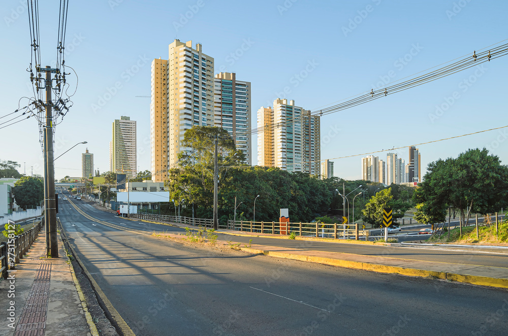 Brazilian large avenue with few cars, electric poles, and few buildings on background. Pedro Chaves dos Santos viaduct of the Ceara Avenue at the capital city, Campo Grande - MS, Brazil.