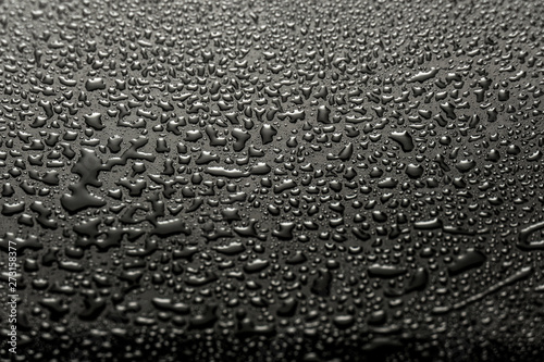 Shiny water drops on a dark glass. Water drops on black surface.