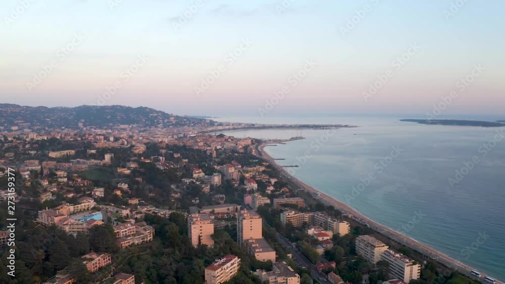 Aerial, pan, drone shot, overlooking the city of Cannes and the coast, at sunset, on a sunny evening, in the French Riviera, in France, Baie de Cannes Aerial, pan, drone shot, overlooking the city of Cannes and the coast, at sunset, on a sunny evening, in the French Riviera, in France, Baie de Cannes