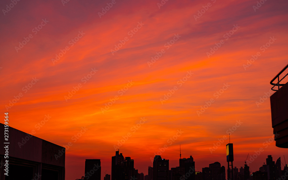 City building in the evening with beautiful red sunset sky and clouds.  Urban landscape with red and orange sunset sky. Twilight with cityscape.  Background quote for life after work all day. Stock