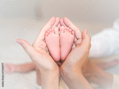 Close up of newborn baby feet on female hands