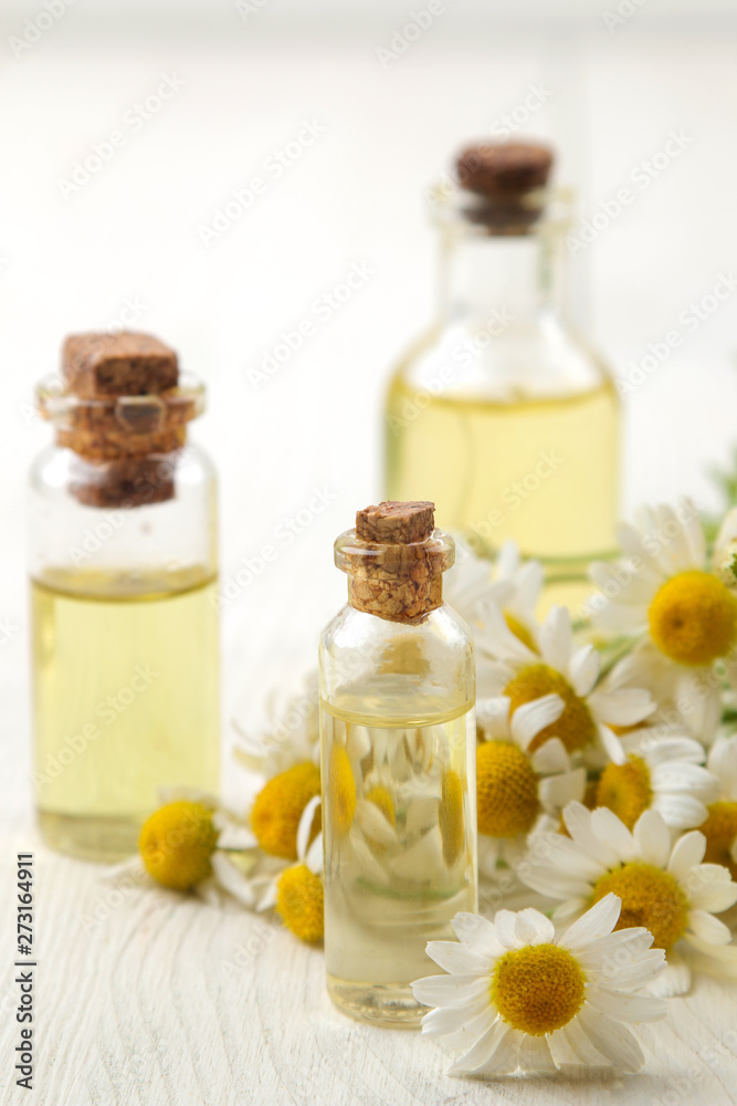 Chamomile. Medicinal little flowers of chamomile with aroma oils on a white wooden table. close-up Chamomile. Medicinal little flowers of chamomile with aroma oils on a white wooden table. close-up