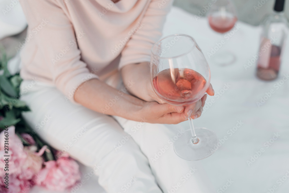 Glass of rose wine in woman's hand on picnic. Cropped. Glass of rose wine in woman's hand on picnic. Cropped.
