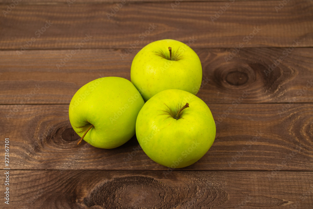 Three delicious golden grenni apples on dark wooden table. Ripe whole apples group heap, tasty healthy fruits Three delicious golden grenni apples on dark wooden table. Ripe whole apples group heap, tasty healthy fruits