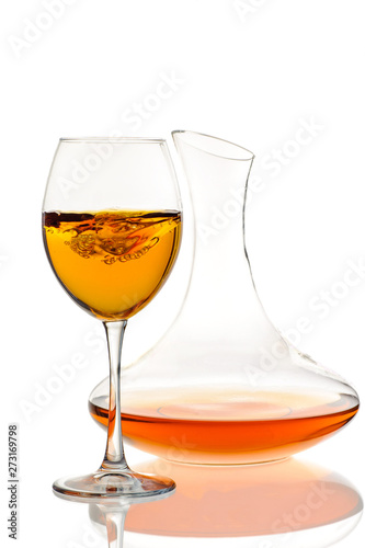 Amber wine. Wine in a glass and decanter. Traditional Georgian wine according to ancient technology. Isolated on white background. Close up and vertical orientation.